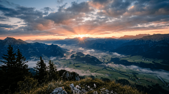 Sunrise breaking through clouds over peaceful valley